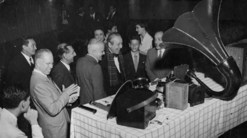 Em solenidade na Associação Brasileira de Televisão pelo 30º aniversário da implantação do rádio no Brasil, Roquette Pinto (de gravata borboleta) observa antigos e então modernos operelhos de radiofonia