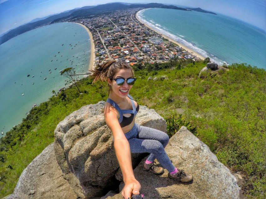 Turista no Morro do Macaco com vista para praia do Canto Grande, em Bombinhas